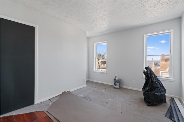 unfurnished room featuring baseboards and a textured ceiling