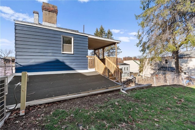 exterior space featuring a lawn, a chimney, and fence