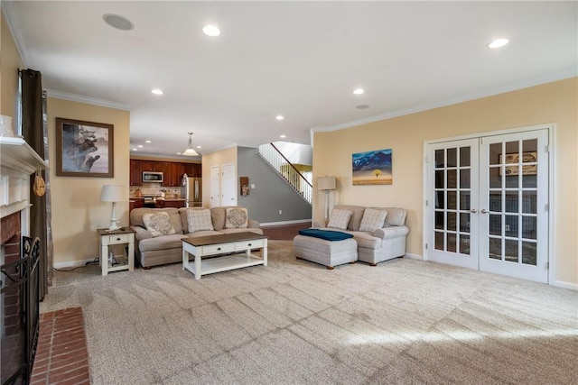 living room with french doors, stairway, ornamental molding, a brick fireplace, and carpet flooring