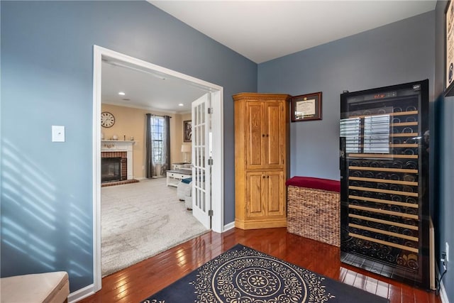 interior space featuring wine cooler, dark wood-style flooring, a fireplace, recessed lighting, and baseboards