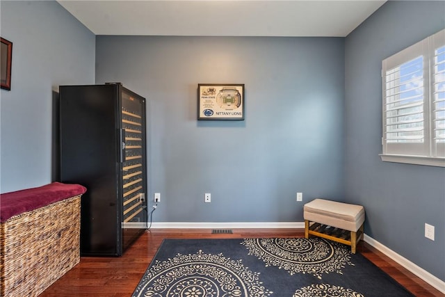 living area with baseboards and wood finished floors