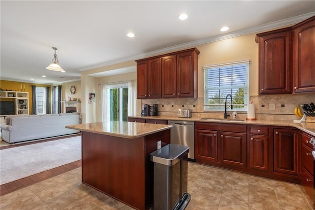 kitchen featuring dishwasher, a kitchen island, open floor plan, light stone countertops, and a sink