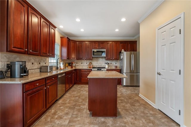 kitchen featuring decorative backsplash, a kitchen island, ornamental molding, stainless steel appliances, and a sink