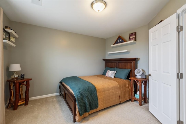 bedroom with baseboards and light colored carpet