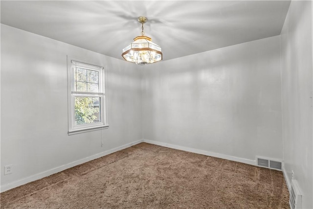 carpeted empty room featuring an inviting chandelier, visible vents, and baseboards