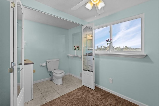 bathroom featuring toilet, ceiling fan, vanity, tile patterned flooring, and baseboards