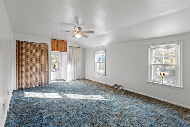 unfurnished bedroom featuring visible vents, baseboards, ceiling fan, vaulted ceiling, and carpet floors