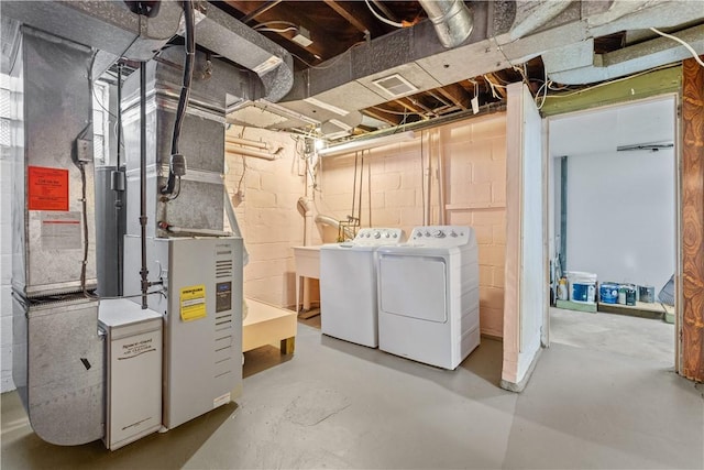 unfinished below grade area featuring washing machine and clothes dryer and visible vents