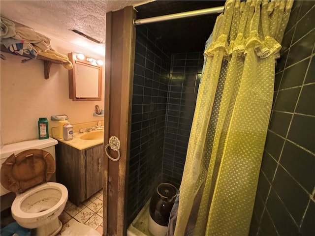 full bathroom with vanity, a tile shower, and toilet