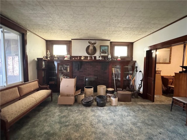 living area with plenty of natural light, carpet, a fireplace, and ornamental molding