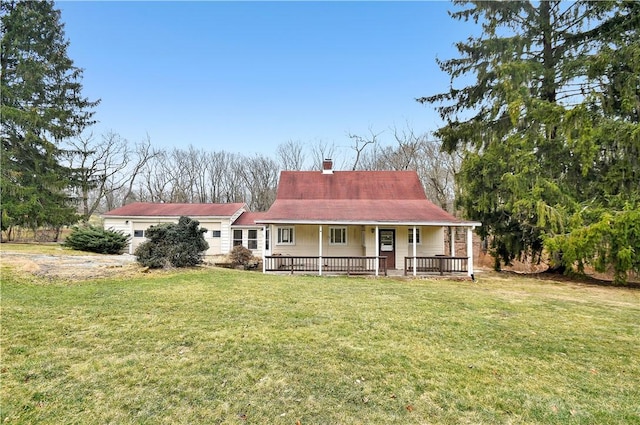 view of front of home featuring a garage, a chimney, a front lawn, and a porch