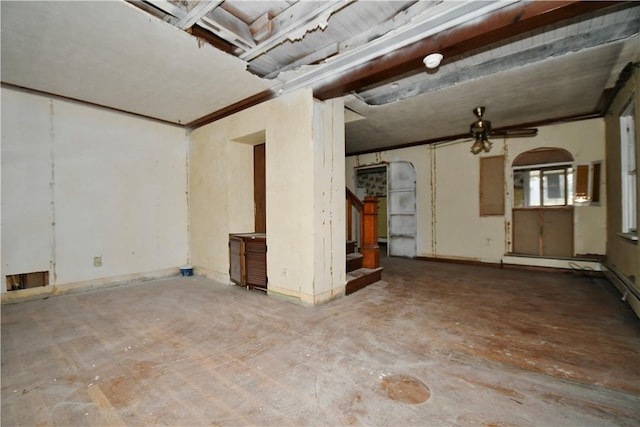 spare room with concrete flooring, arched walkways, and stairway