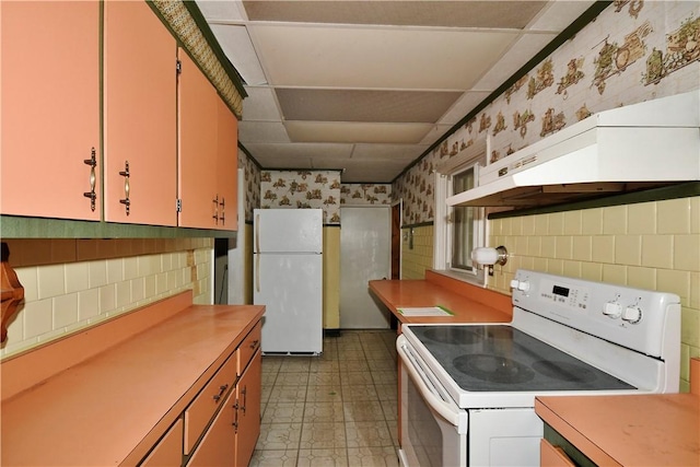 kitchen with tasteful backsplash, light countertops, white appliances, and under cabinet range hood