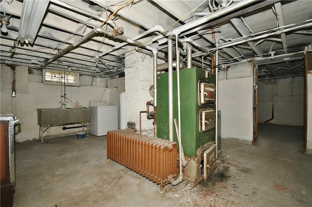 below grade area with radiator, washer / clothes dryer, and a sink