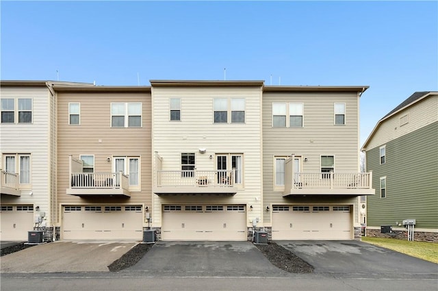 rear view of property featuring central AC and an attached garage