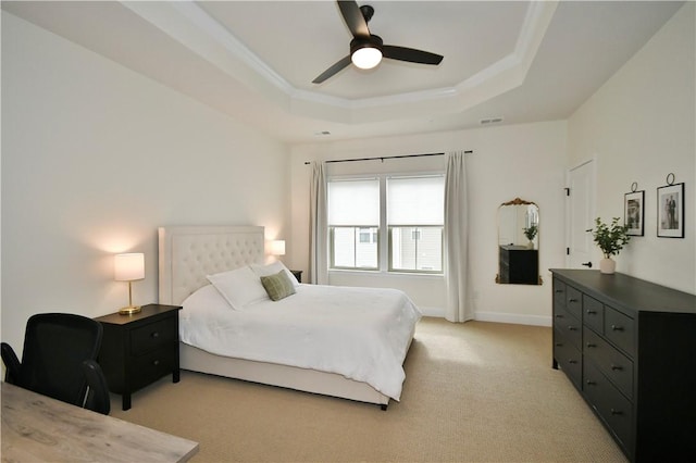 bedroom with a raised ceiling, visible vents, light carpet, ceiling fan, and baseboards