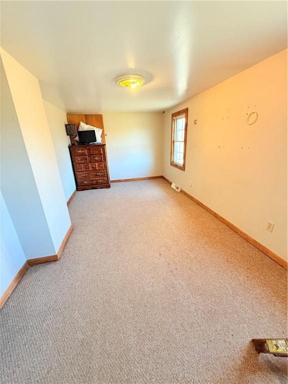 interior space with light carpet, visible vents, and baseboards