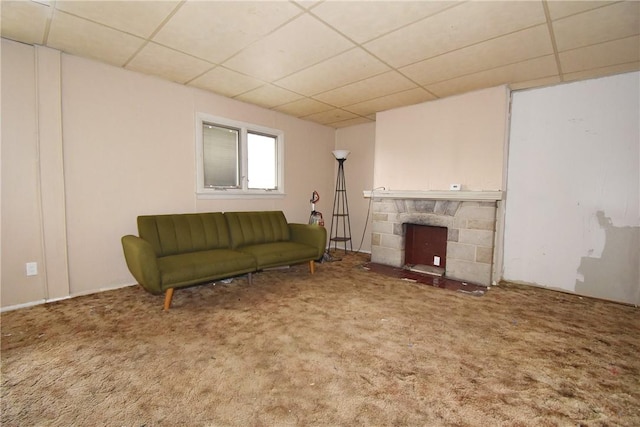 unfurnished living room with a paneled ceiling, carpet flooring, and a fireplace