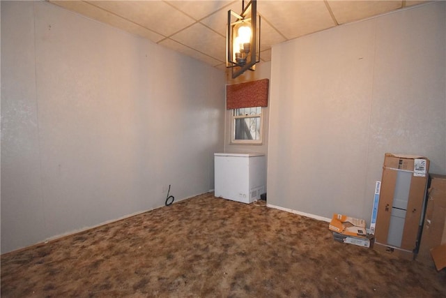 carpeted spare room featuring a paneled ceiling