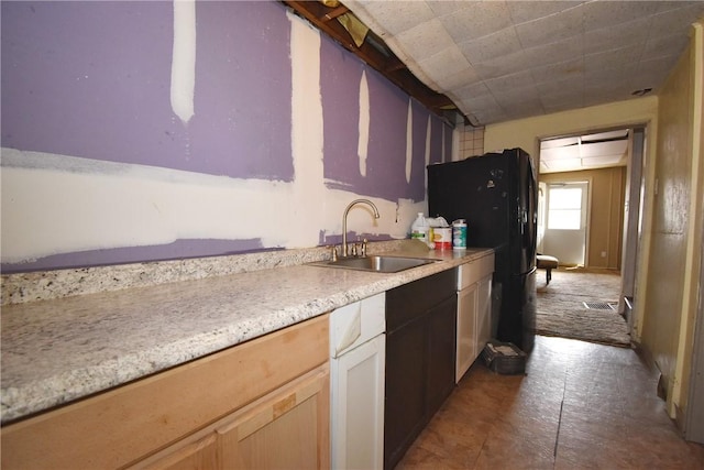 kitchen featuring visible vents, light countertops, a sink, and freestanding refrigerator