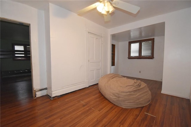 interior space with a ceiling fan, a baseboard radiator, and wood finished floors