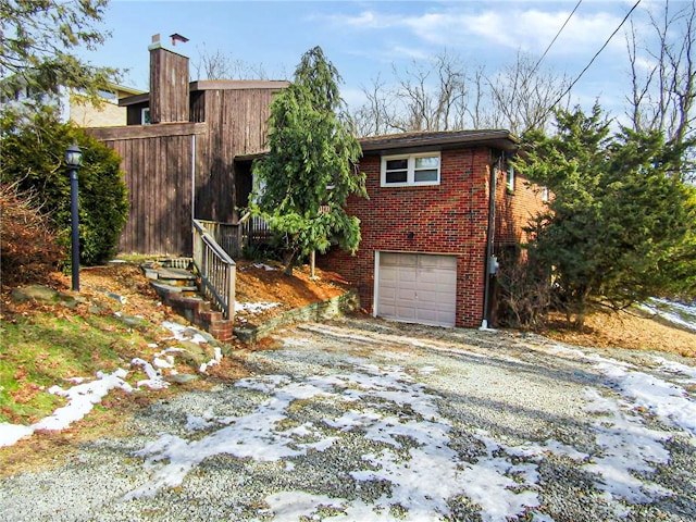 view of front of property with a garage, driveway, and brick siding