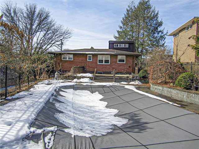 exterior space with a fenced front yard and brick siding