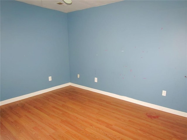 empty room featuring light wood-type flooring and baseboards