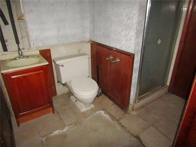 bathroom featuring toilet, a shower stall, and vanity