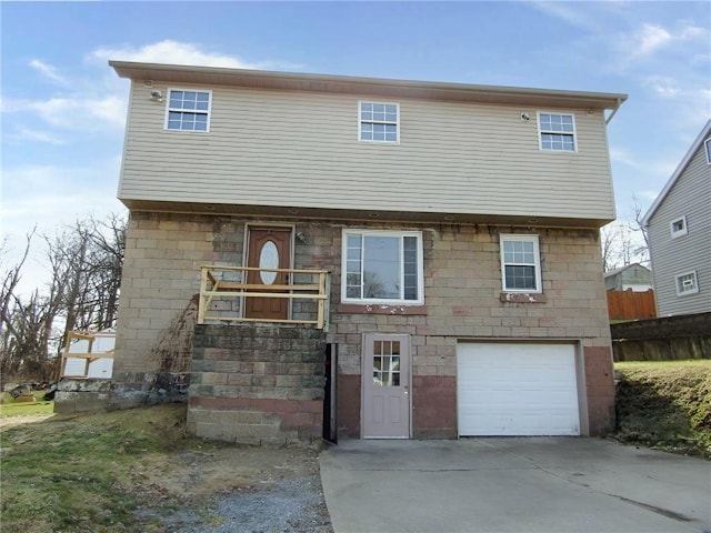 view of front of home featuring driveway, an attached garage, and fence