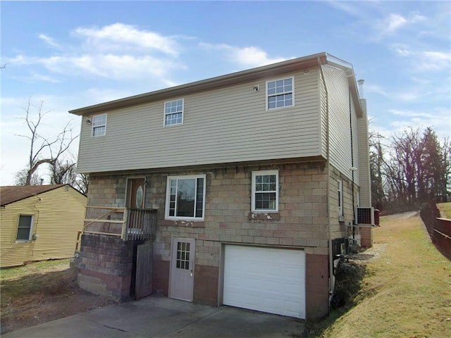 rear view of house featuring an attached garage and driveway