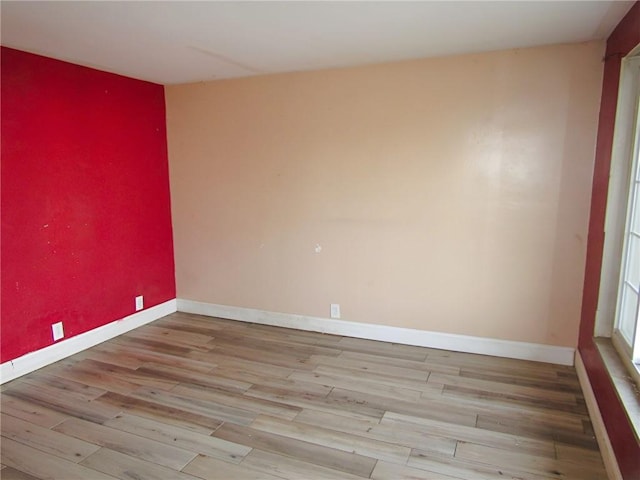 spare room featuring baseboards and wood finished floors