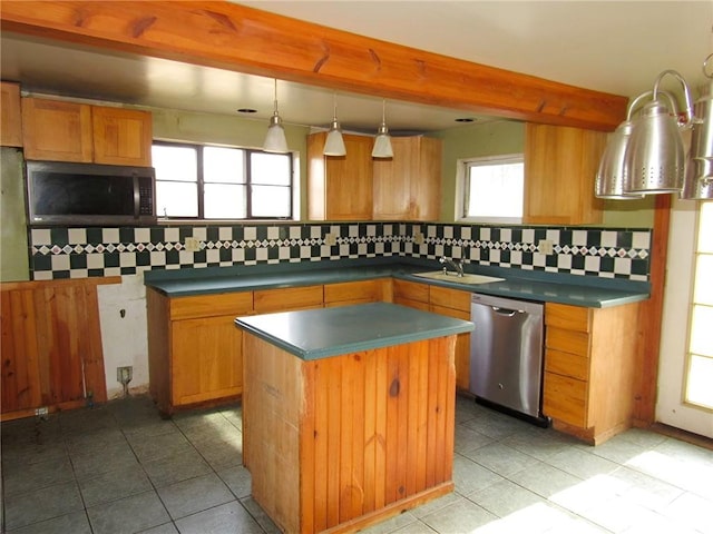 kitchen with a kitchen island, a sink, appliances with stainless steel finishes, beam ceiling, and tasteful backsplash