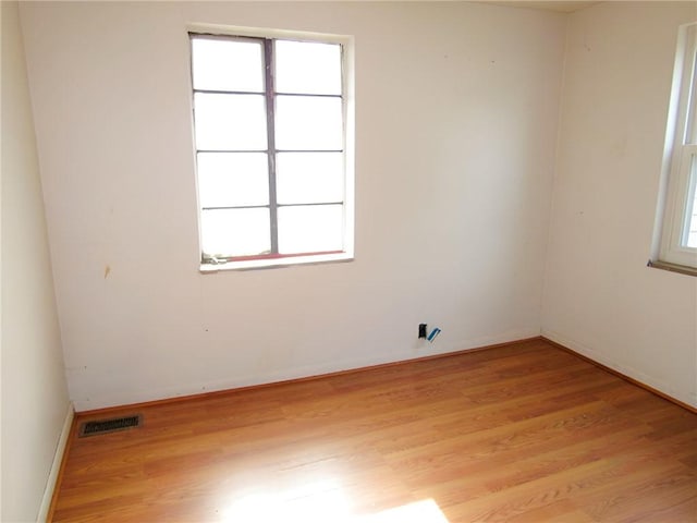 spare room featuring visible vents, a wealth of natural light, and light wood-style flooring