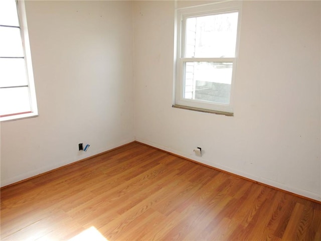 spare room featuring light wood-style flooring and baseboards