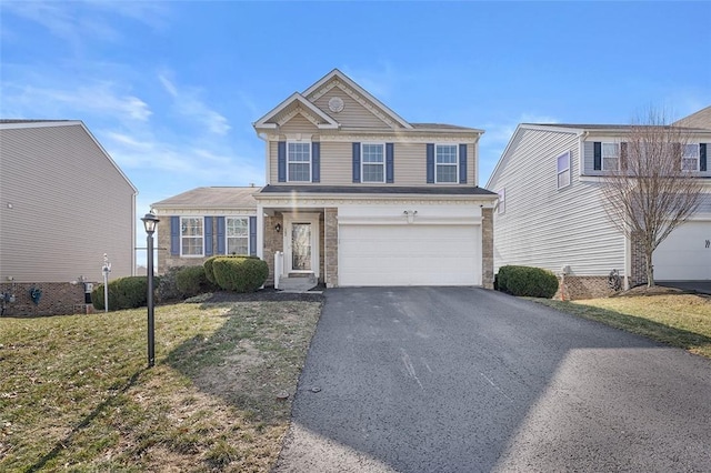 traditional home featuring a garage, aphalt driveway, and a front yard