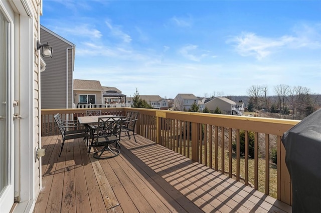 deck featuring outdoor dining space, area for grilling, and a residential view