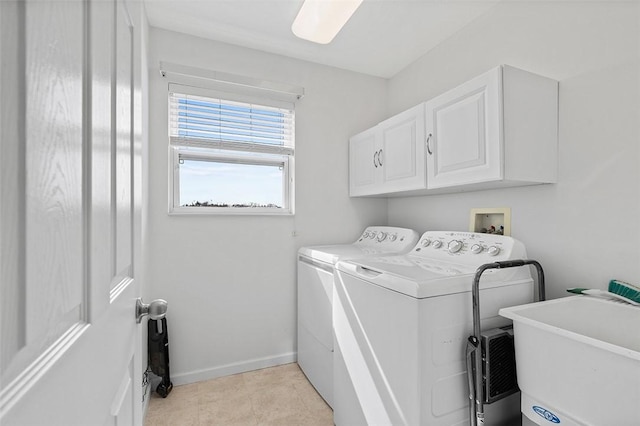 clothes washing area featuring cabinet space, baseboards, washer and clothes dryer, a sink, and light tile patterned flooring