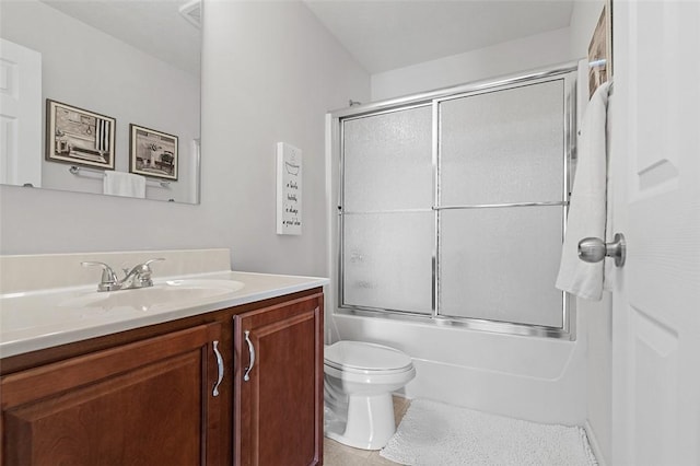 bathroom featuring enclosed tub / shower combo, vanity, and toilet