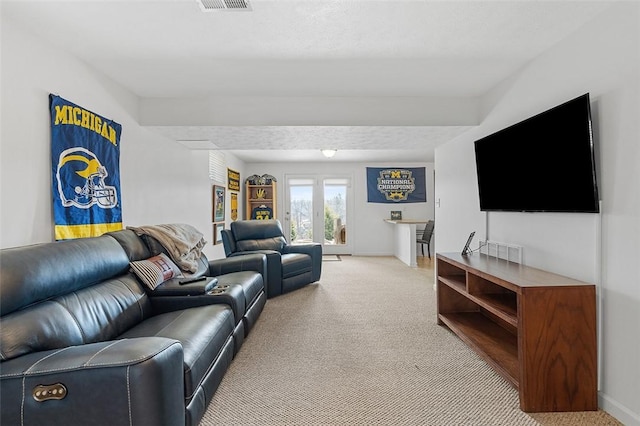 living area with visible vents, baseboards, and light colored carpet