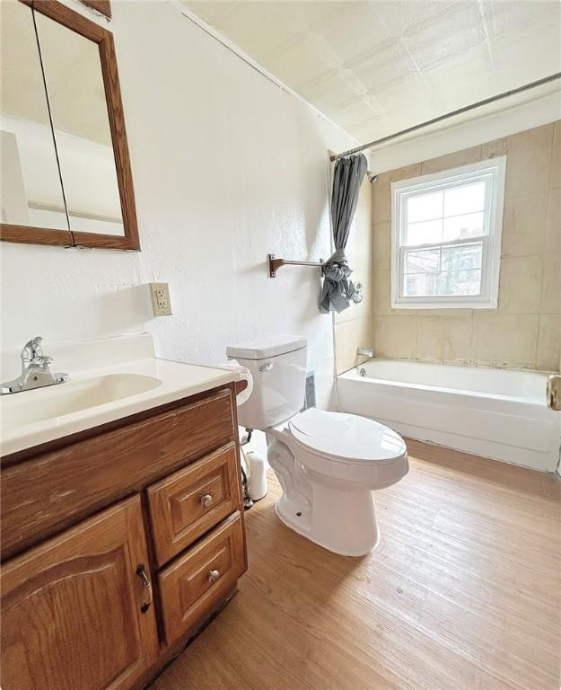 full bathroom with toilet, shower / bathing tub combination, wood finished floors, and vanity