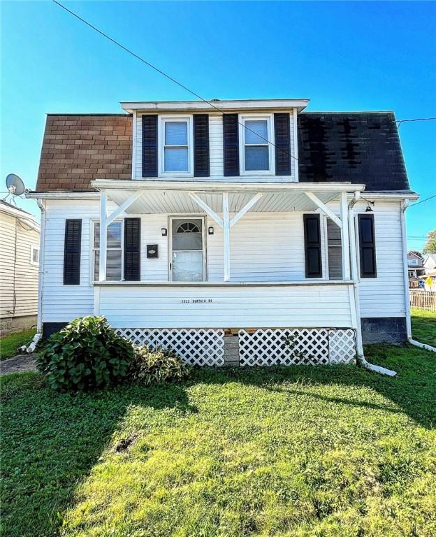 view of front of house featuring a porch, a front yard, and a shingled roof