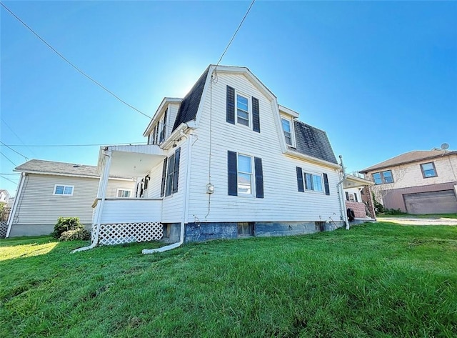 back of property with a shingled roof, a lawn, and a gambrel roof