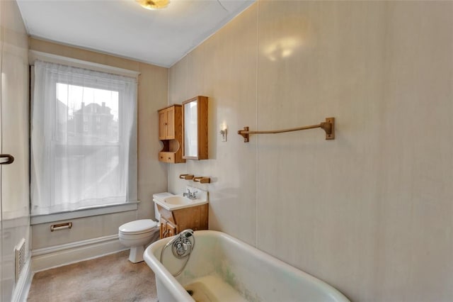 full bathroom featuring a sink, a freestanding bath, visible vents, and toilet