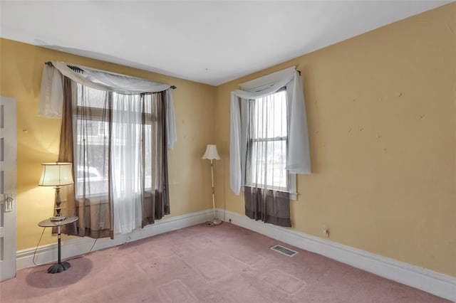 empty room featuring carpet floors, visible vents, and baseboards