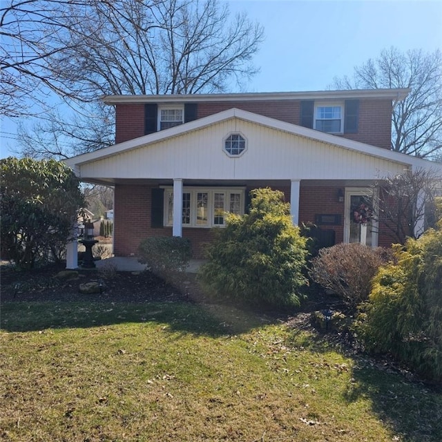 view of front facade with a front yard and brick siding