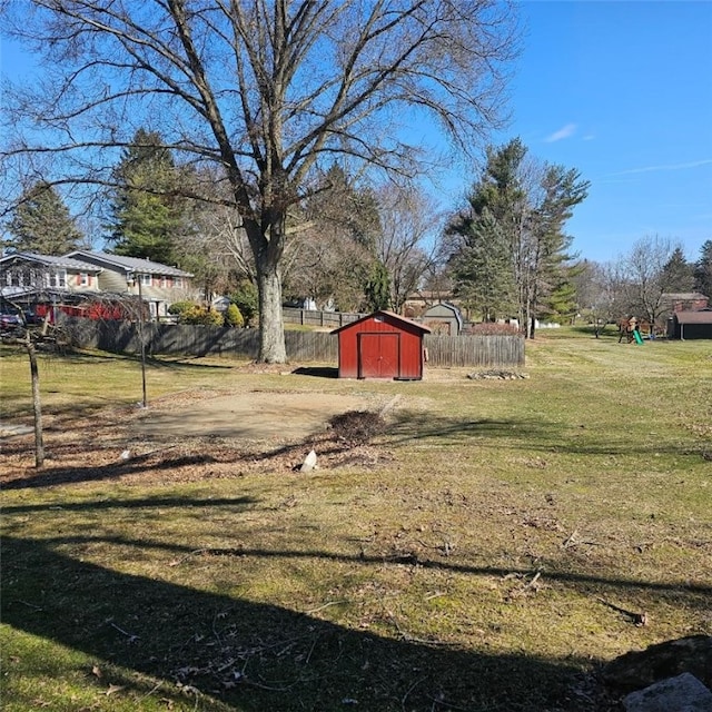 view of yard with a storage shed, an outdoor structure, and fence