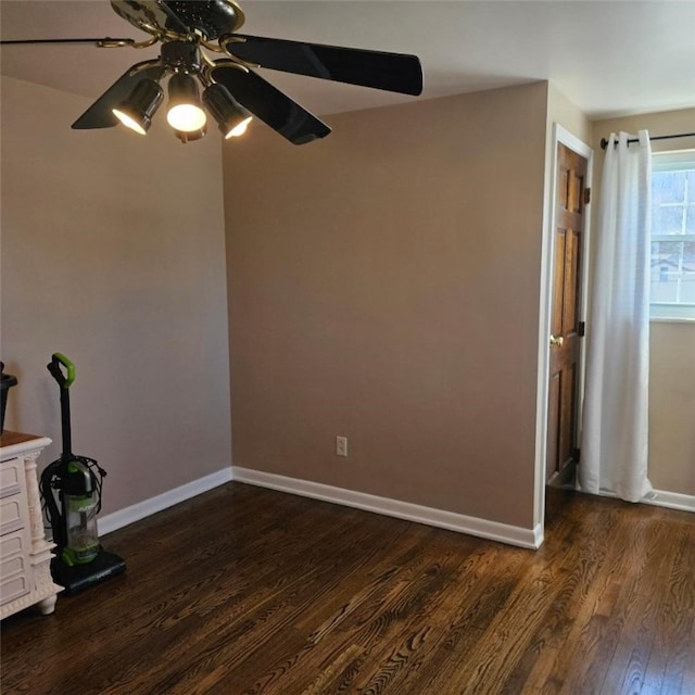 spare room with ceiling fan, baseboards, and dark wood-style flooring