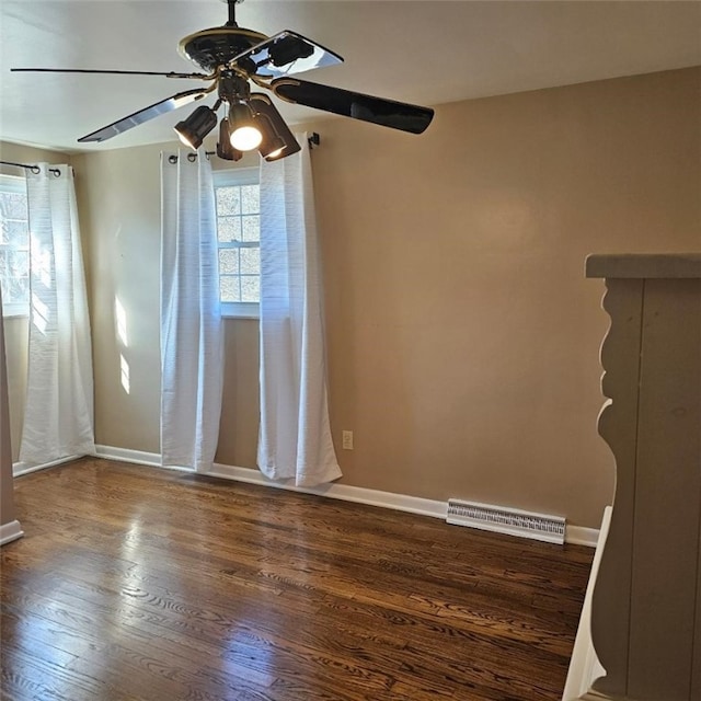 unfurnished room featuring visible vents, baseboards, and wood finished floors