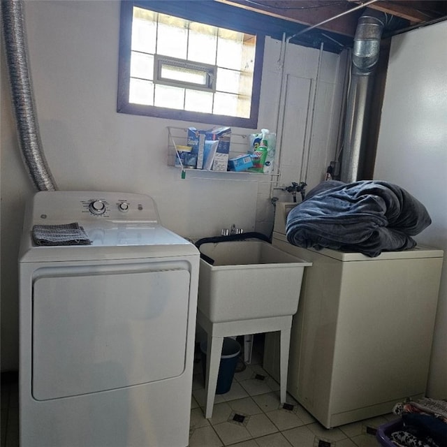 laundry room with laundry area, washer and clothes dryer, and light tile patterned floors